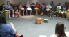 Children and their parents form a circle to play songs of various origins, including Cherokee, Nigerian, and Latin, on more than 30 drums at Newport News (Va.) Public Library System’s Grissom branch July 6. The drums were provided by Connie Ralston, who spoke and sang about her 25-year career as a drummer.  Credit: Mike Wagner/Newport News Public Library System.
