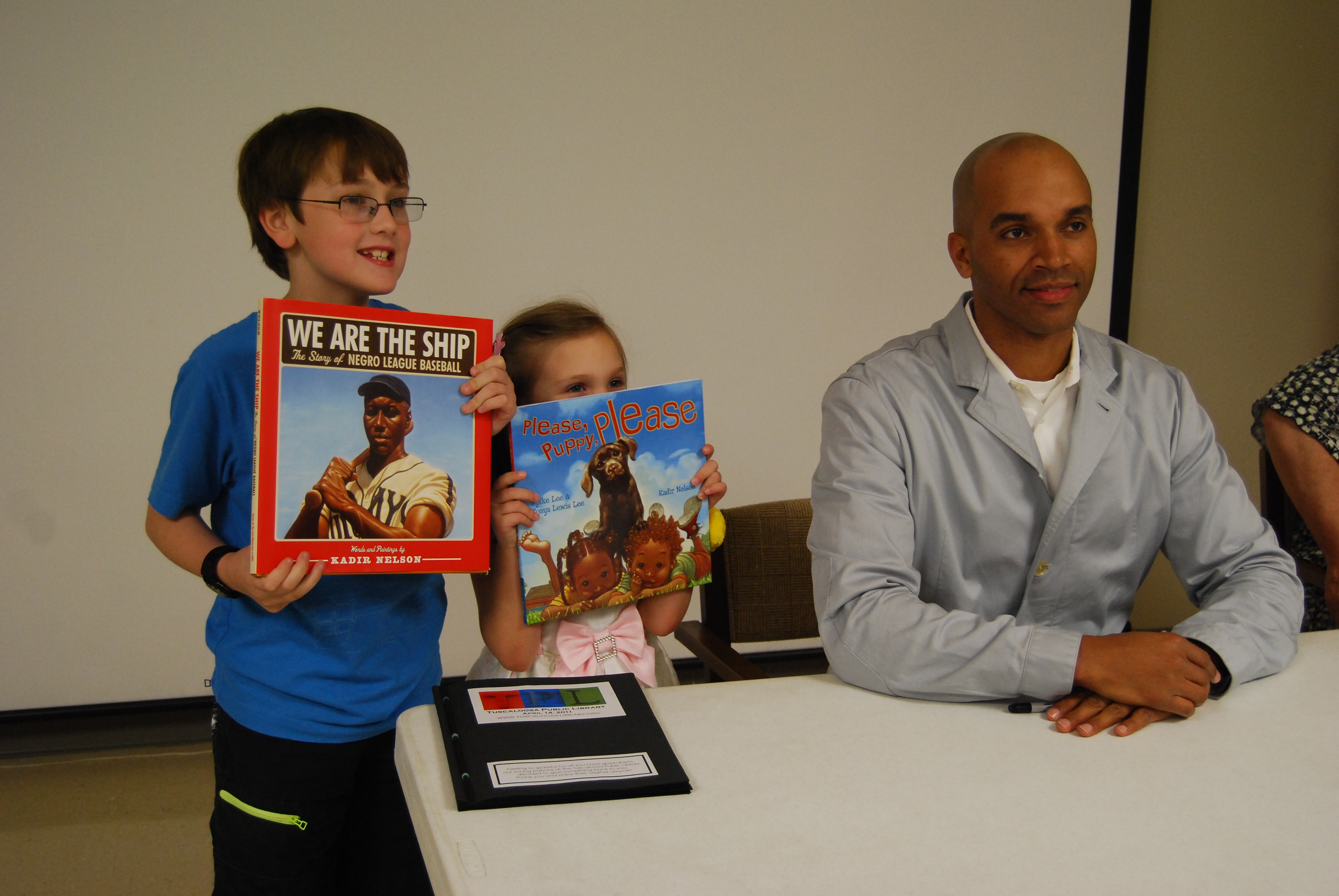 Award-winning author and illustrator Kadir Nelson joins (from left) Blaine and Kyra Richardson during a book signing at Tuscaloosa (Ala.) Public Library’s main branch.